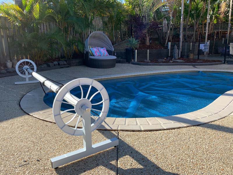 Swimming pool cover with roller