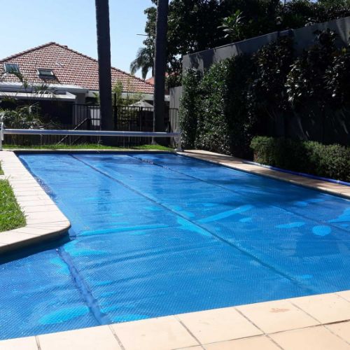 Daisy blue pool cover paired with pool cover roller
