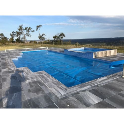 Pool cover neatly rolled on Daisy ST roller system