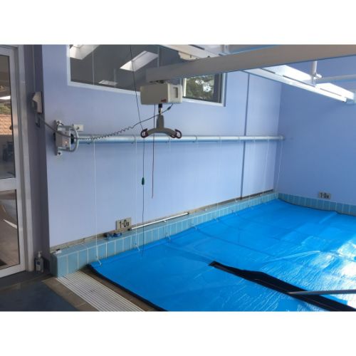 Daisy powered pool roller installed beside swimming pool